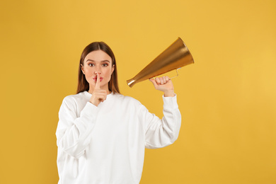 Photo of Young woman with vintage megaphone on yellow background