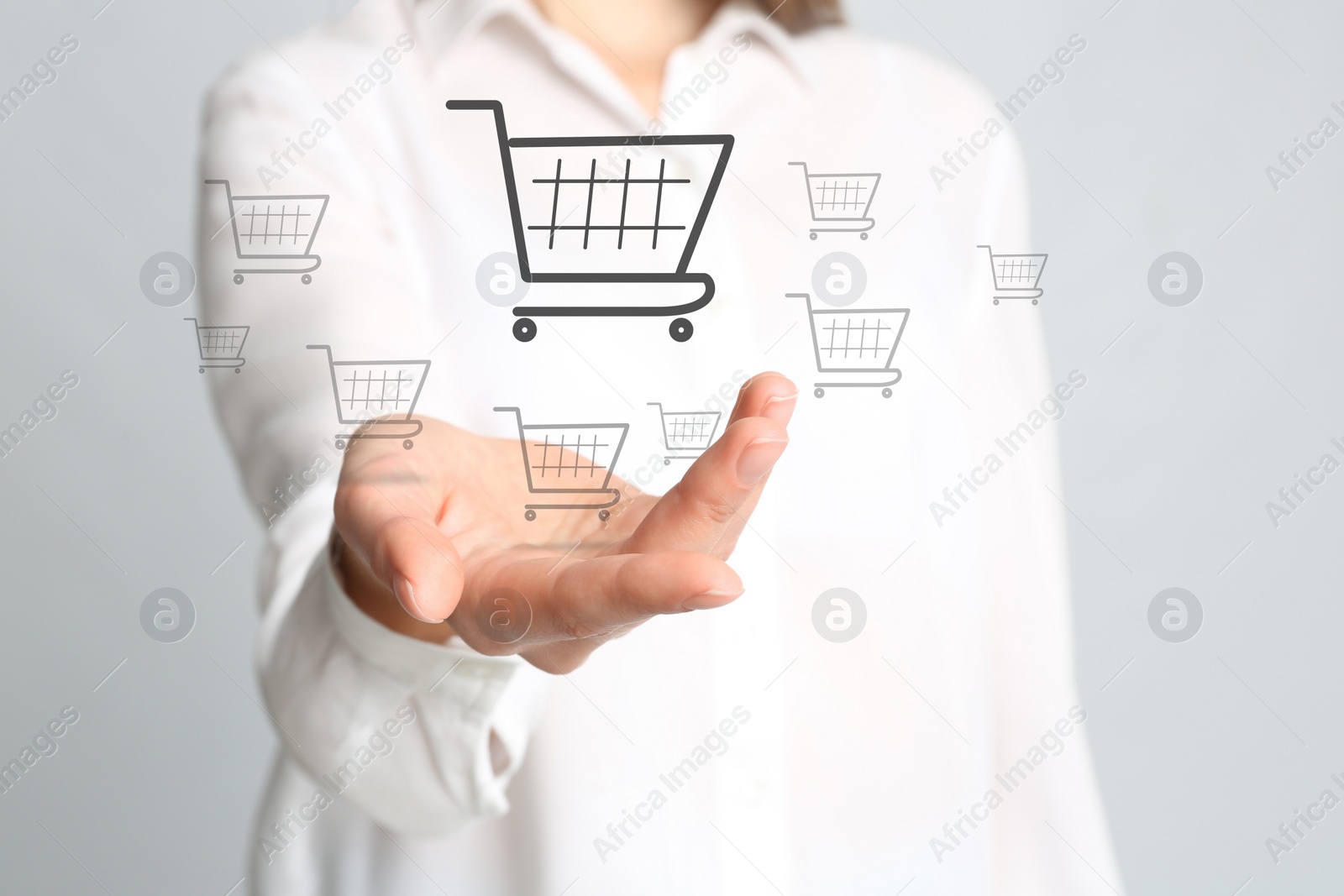 Image of Woman demonstrating virtual image of shopping cart on light background, closeup