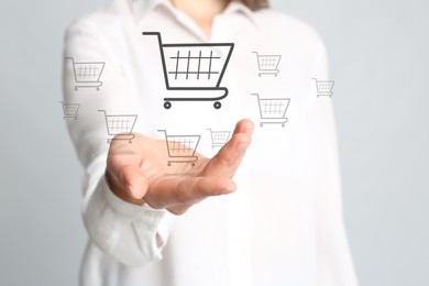 Image of Woman demonstrating virtual image of shopping cart on light background, closeup
