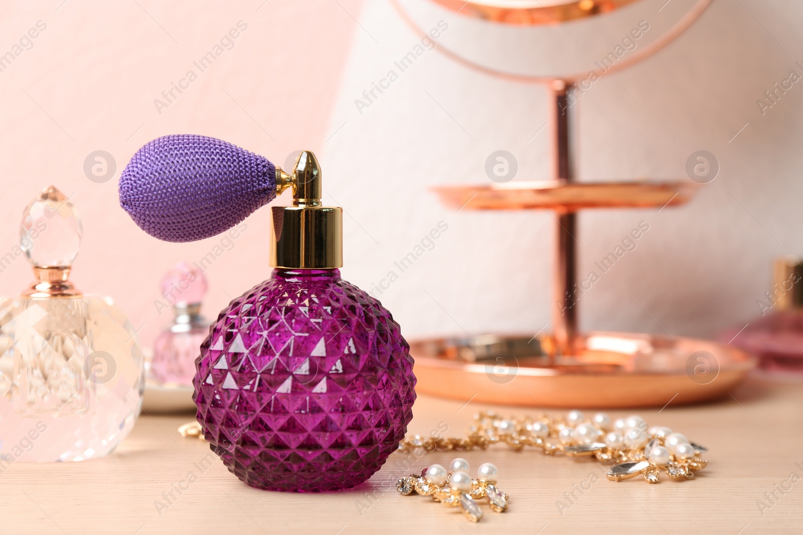 Photo of Perfume bottles and jewellery on dressing table