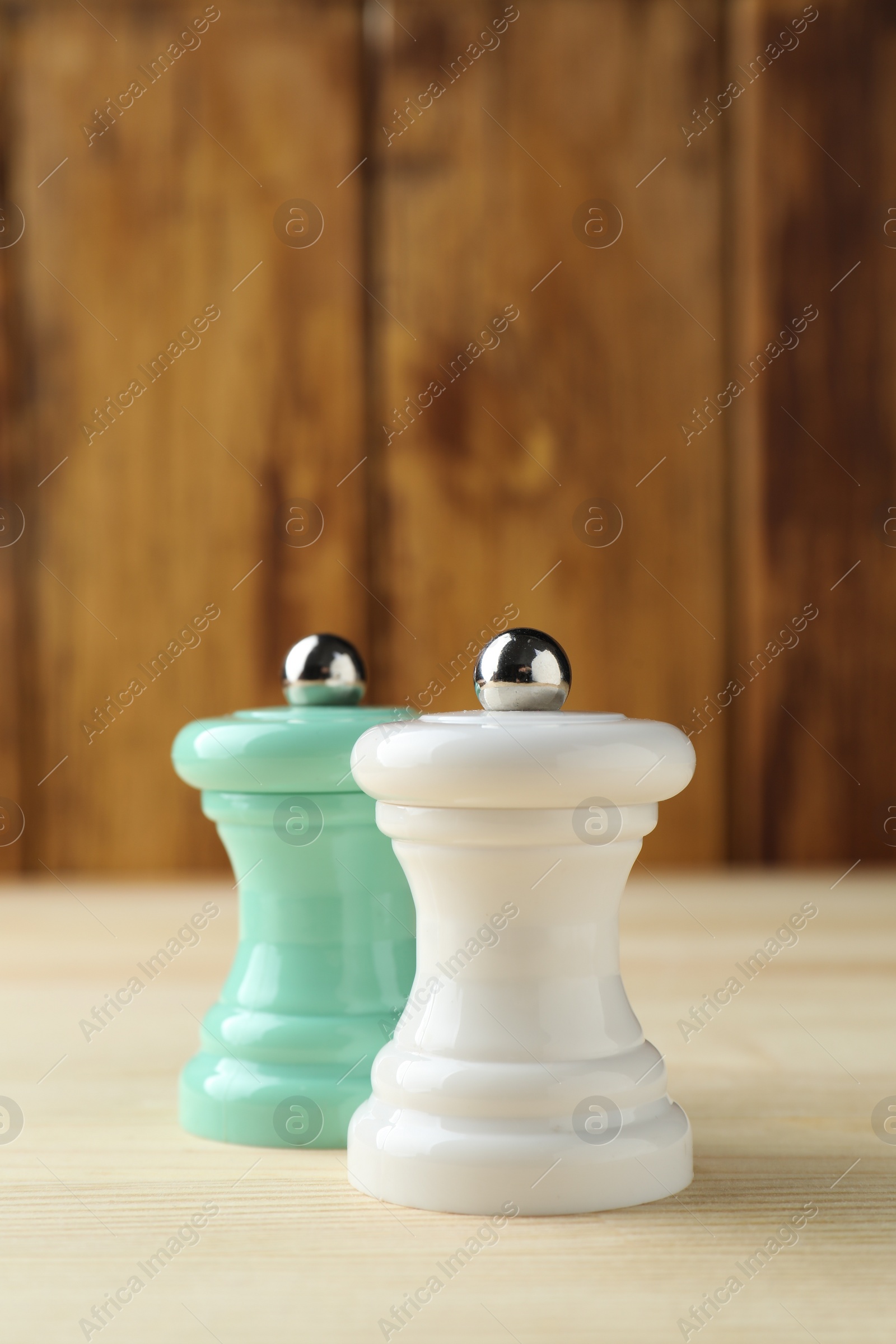 Photo of Salt and pepper shakers on light wooden table