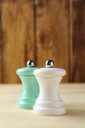 Photo of Salt and pepper shakers on light wooden table