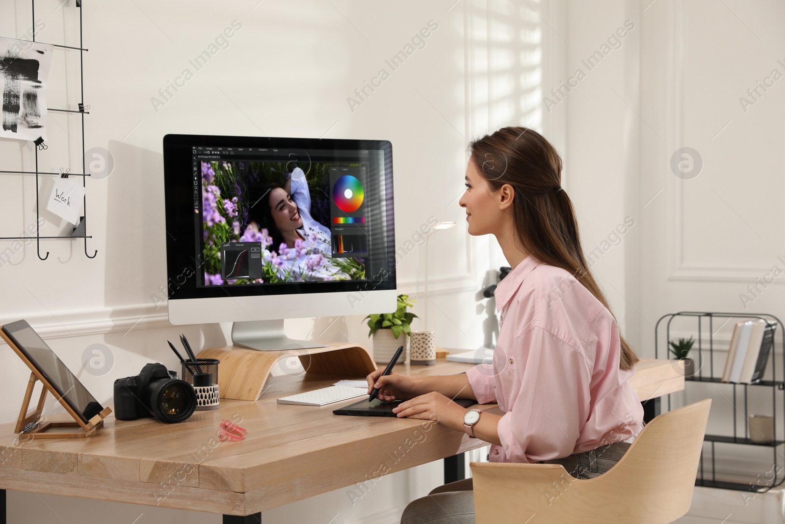 Photo of Professional retoucher working on graphic tablet at desk in office