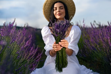 Photo of Beautiful young woman with bouquet in lavender field