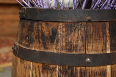 Photo of Traditional wooden barrel and decorative branches outdoors, closeup