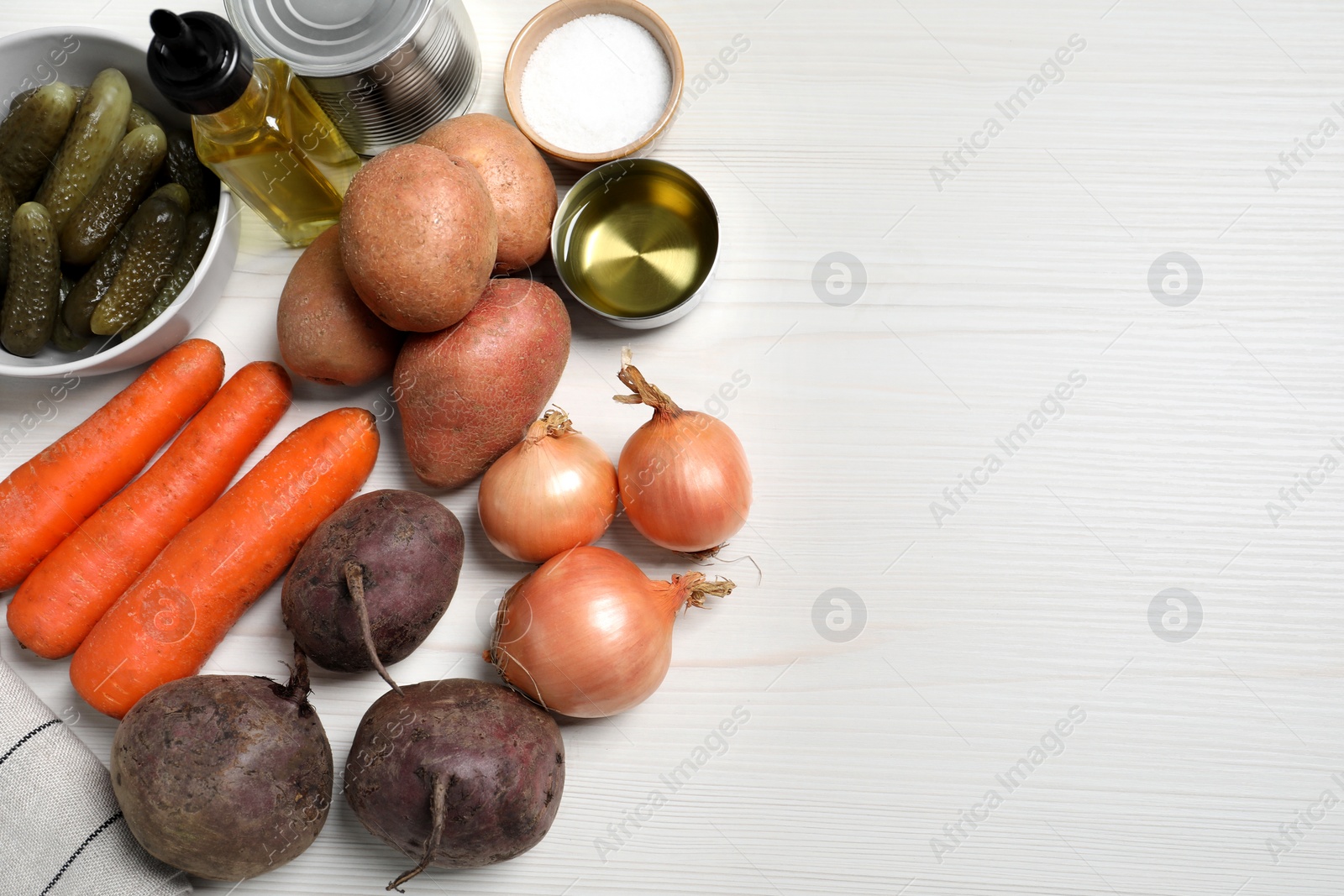 Photo of Cooking vinaigrette salad. Many fresh vegetables and other ingredients on white wooden table, flat lay. Space for text