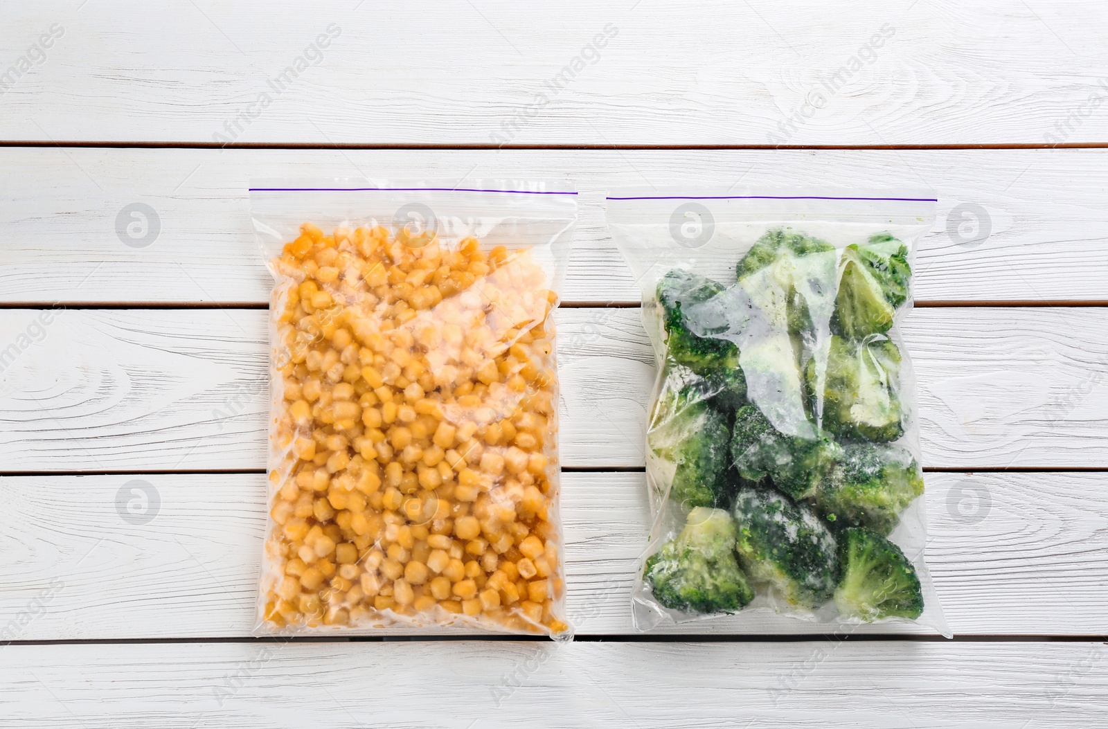 Photo of Different frozen vegetables on white wooden table, flat lay