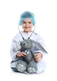 Photo of Cute child playing doctor with stuffed toy on white background