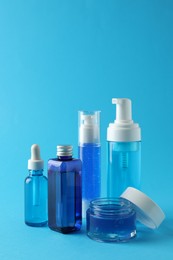 Set of luxury cosmetic products on light blue background