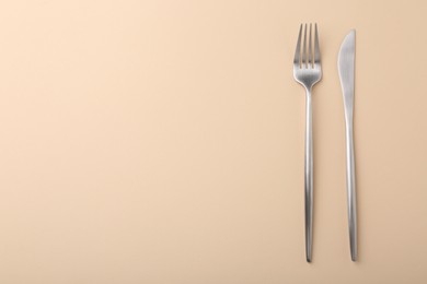 Stylish cutlery on beige table, top view. Space for text