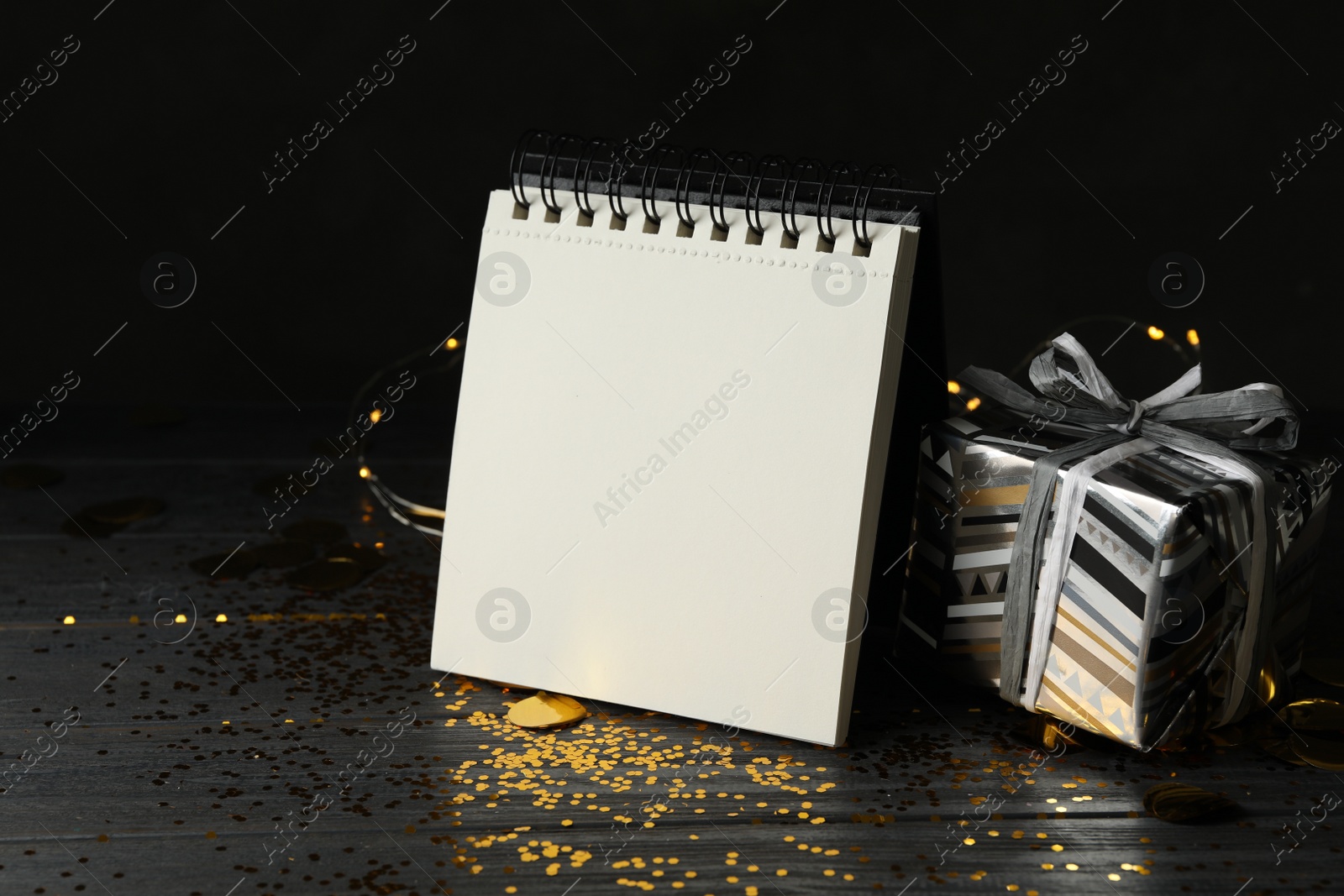 Photo of Notepad with space for text and gift on wooden table