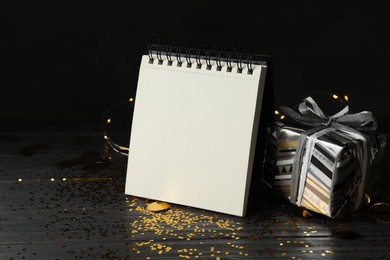 Notepad with space for text and gift on wooden table