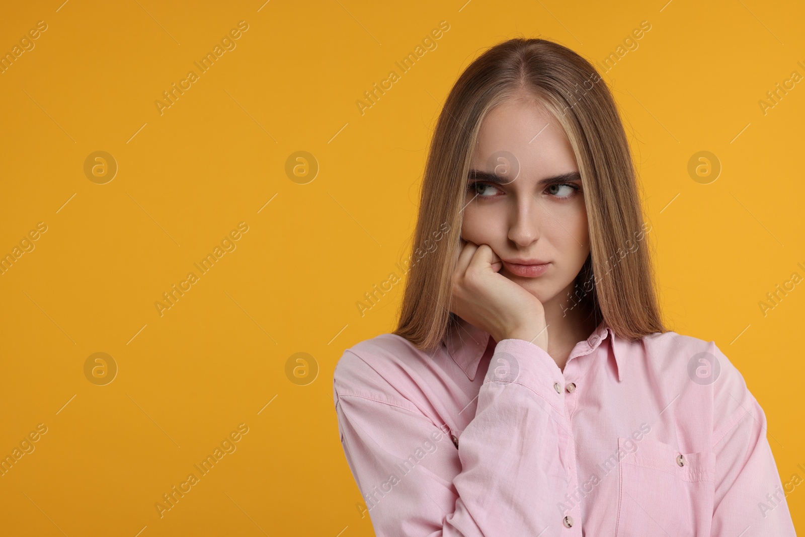 Photo of Resentful woman on orange background, space for text