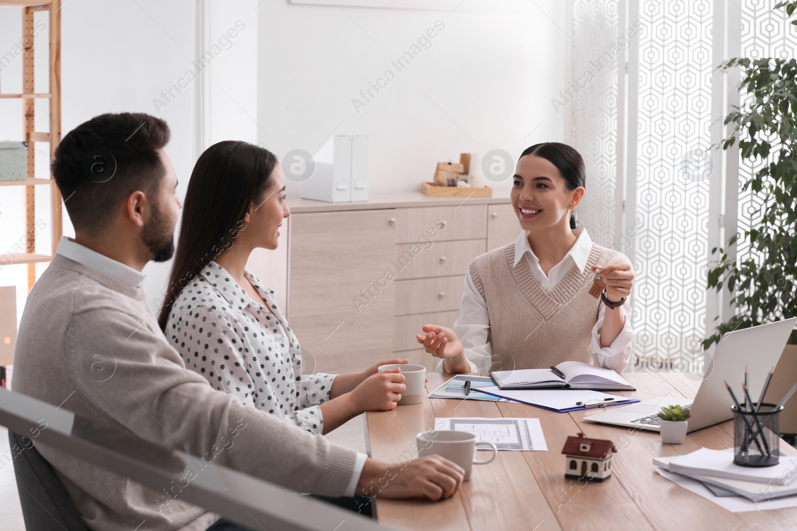 Photo of Real estate agent working with young couple in office. Mortgage concept