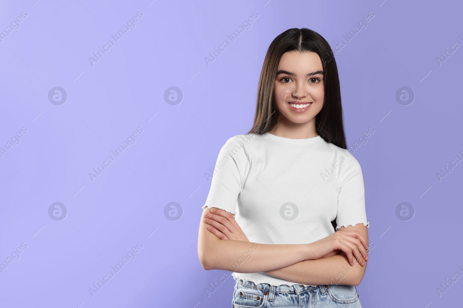 Photo of Portrait of happy teenage girl on violet background. Space for text