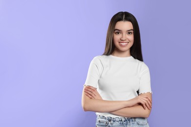 Portrait of happy teenage girl on violet background. Space for text
