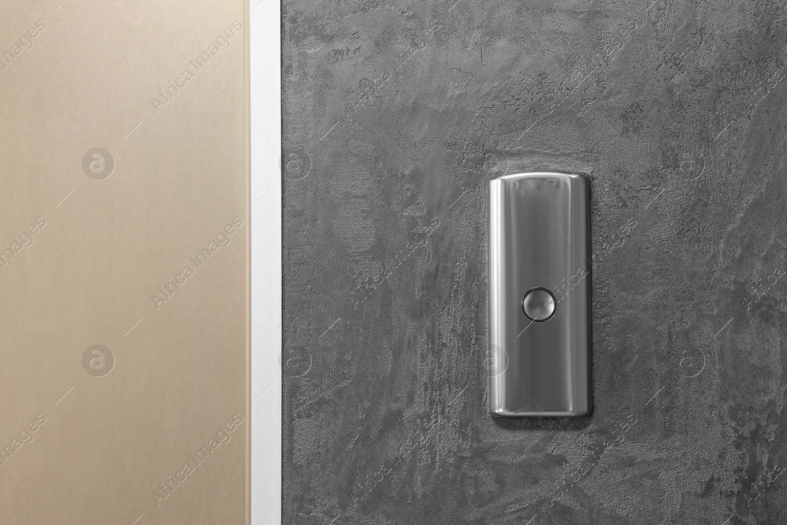 Photo of Elevator call button on grey textured wall