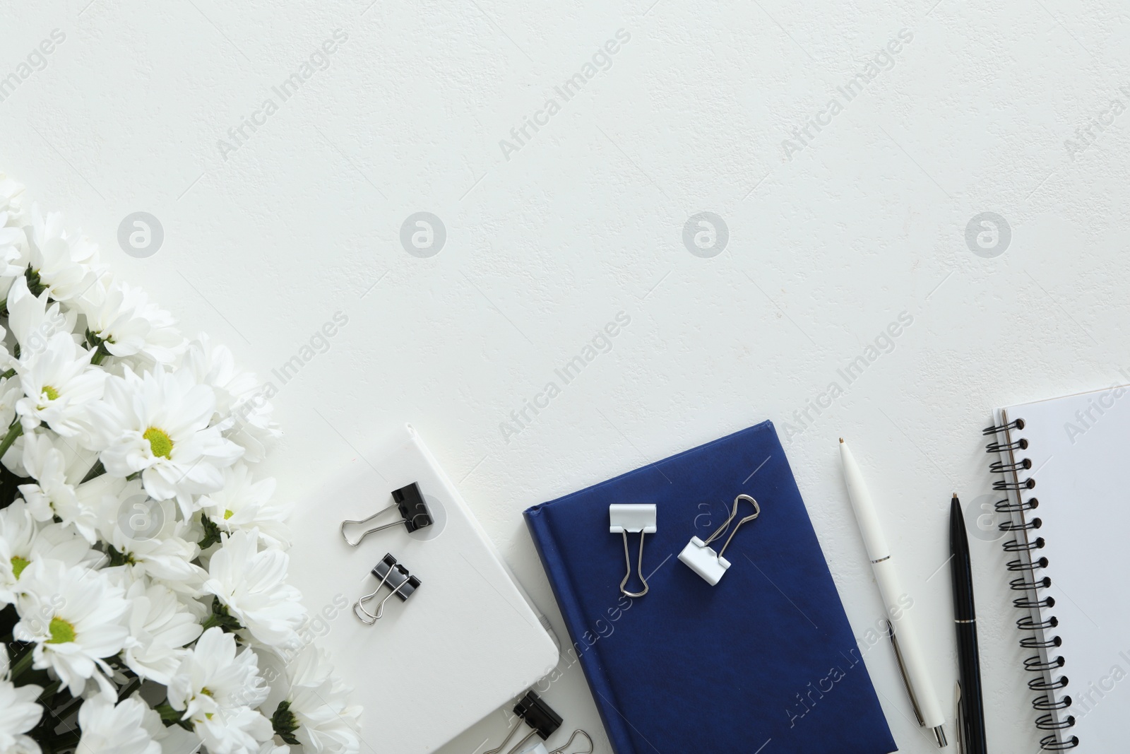 Photo of Beautiful flowers and stationery on white background, flat lay with space for text. Teacher's Day