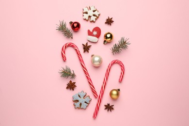 Photo of Flat lay composition with sweet candy canes and Christmas decor on pink background