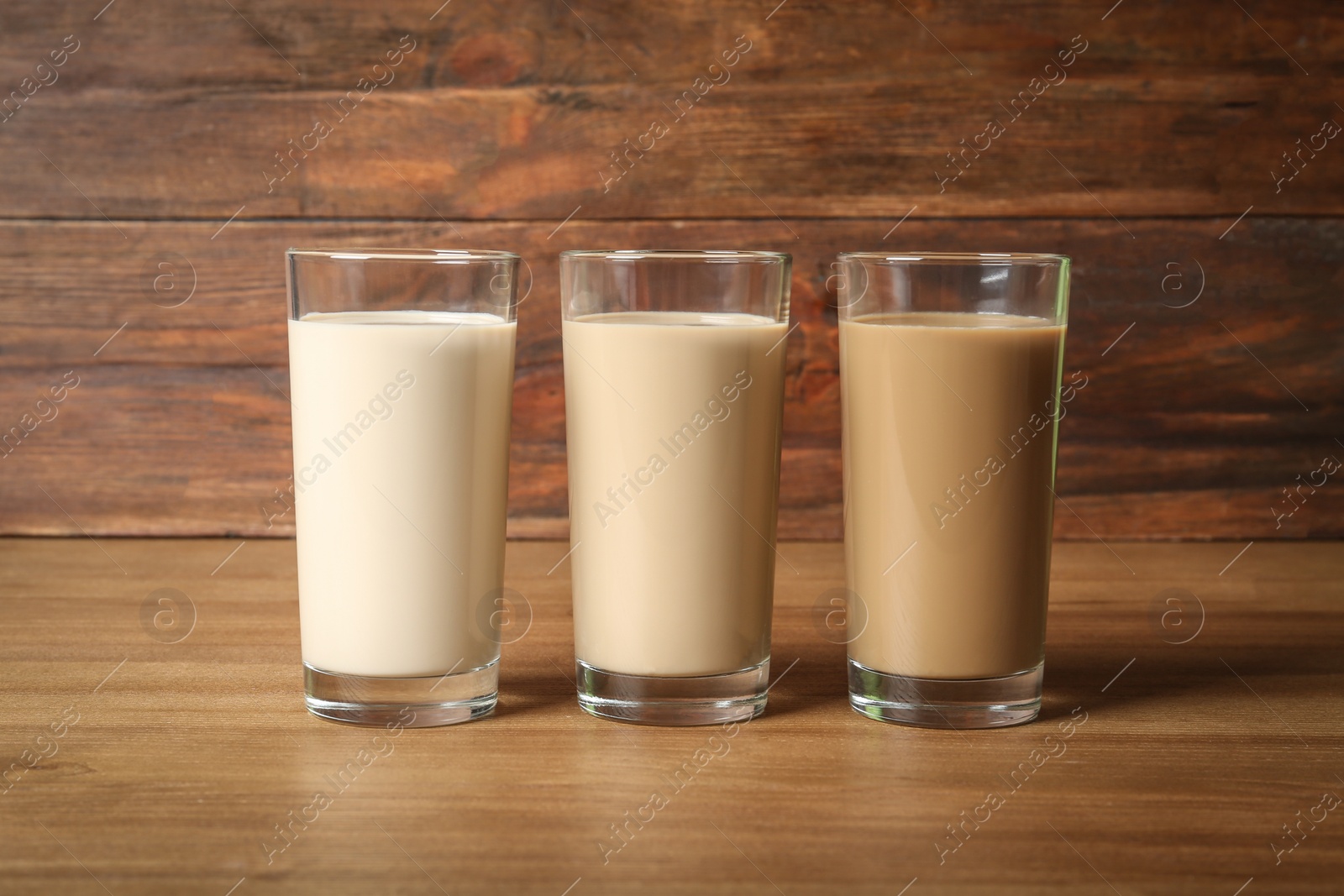 Photo of Glasses with protein shakes on wooden table