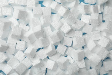 Photo of Many styrofoam cubes on light blue background, top view