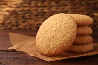 Photo of Delicious Danish butter cookies on wooden table, closeup. Space for text