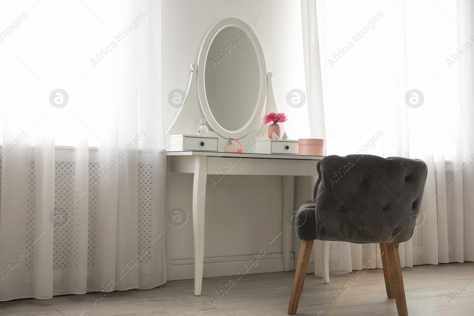 Photo of Elegant white dressing table and armchair in light room