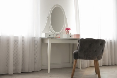 Photo of Elegant white dressing table and armchair in light room