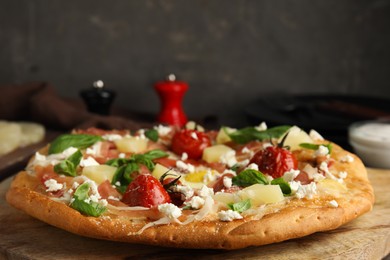 Photo of Pita pizza with prosciutto, pineapple, grilled tomatoes and egg on wooden table, closeup