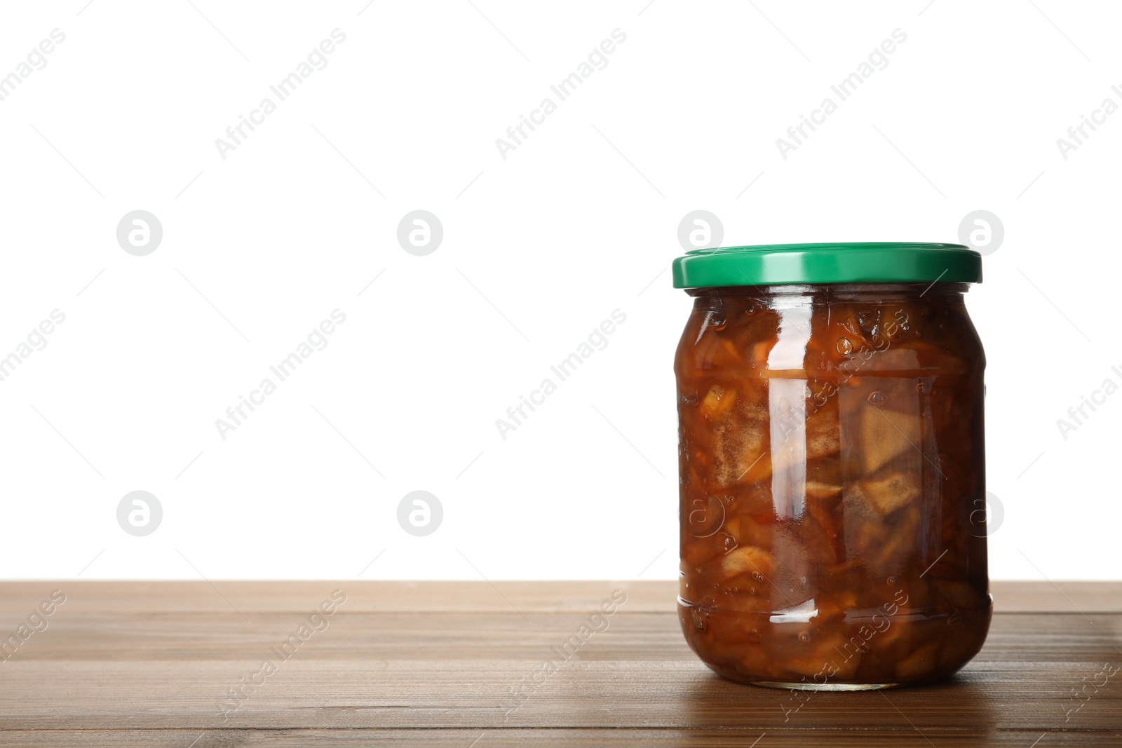 Photo of Glass jar with apple jam on wooden table against white background, space for text
