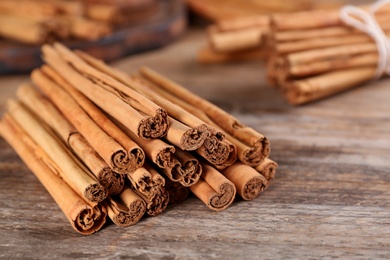 Aromatic cinnamon sticks on wooden table, closeup