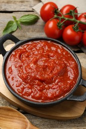 Photo of Homemade tomato sauce in bowl on wooden table, closeup