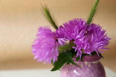 Photo of Bouquet of beautiful wildflowers in vase on beige background, closeup