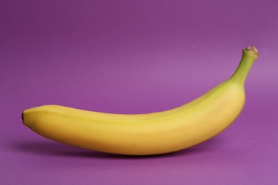 Ripe sweet yellow banana on purple background