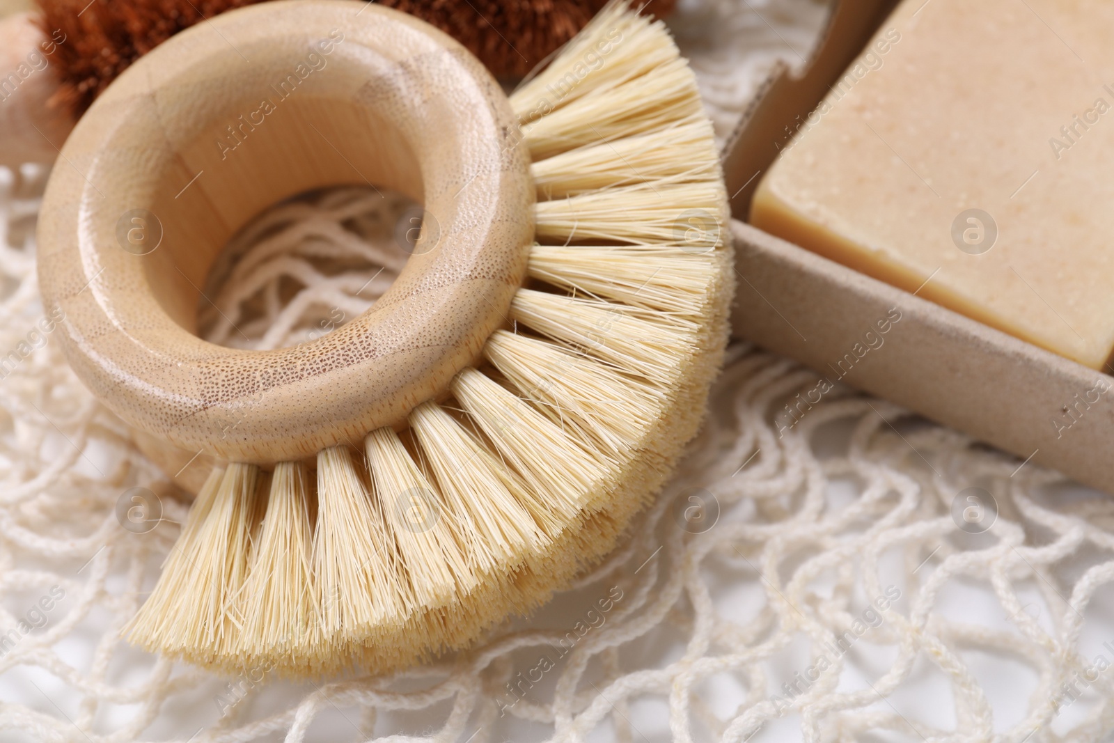 Photo of Cleaning brush and soap bar on table, closeup