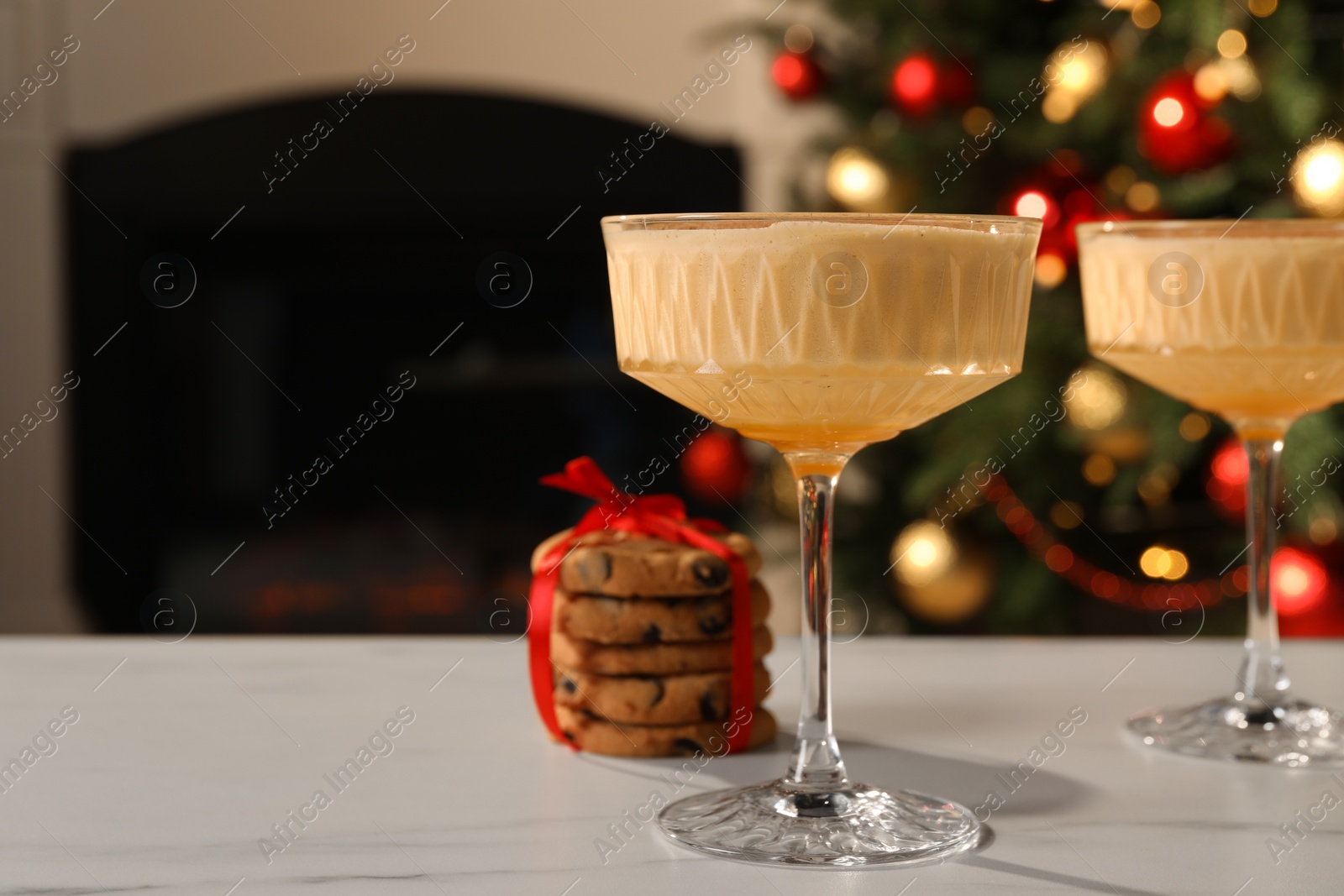 Photo of Tasty eggnog and cookies on white marble table indoors. Space for text