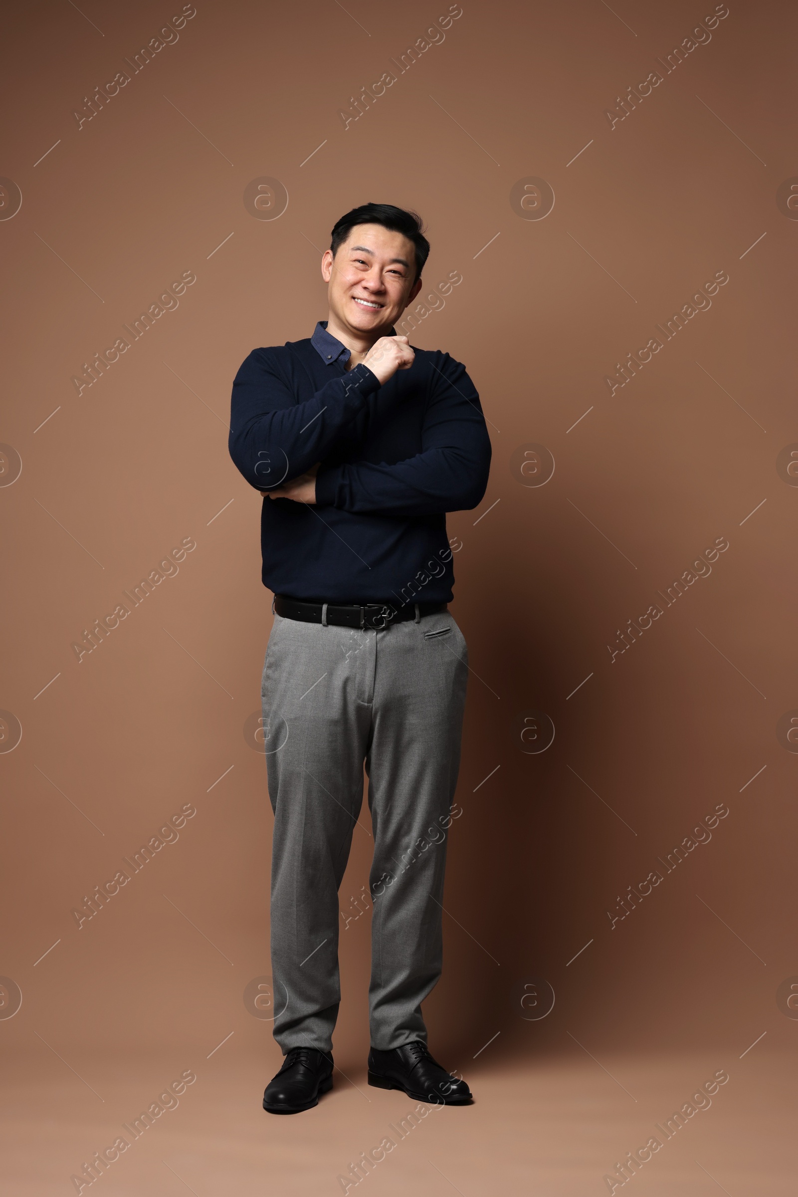 Photo of Full length portrait of happy man on brown background