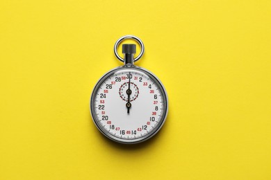 Vintage timer on yellow background, top view