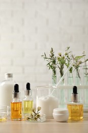 Organic cosmetic products, natural ingredients and laboratory glassware on wooden table