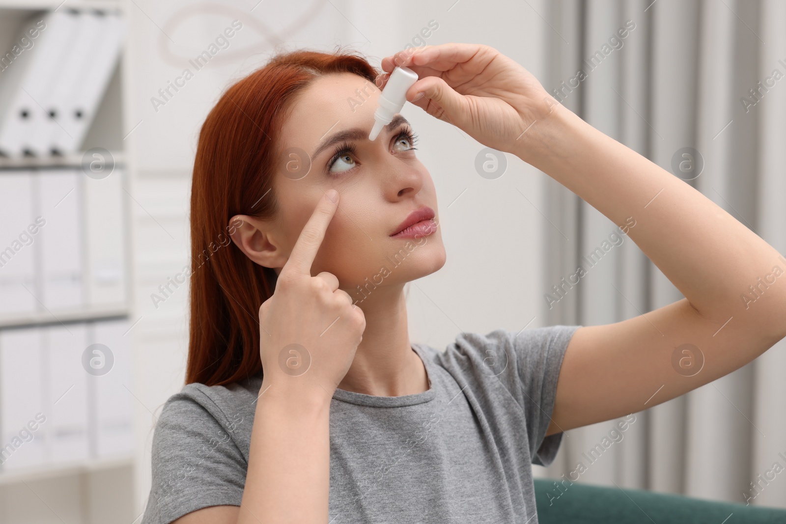 Photo of Woman applying medical eye drops at home