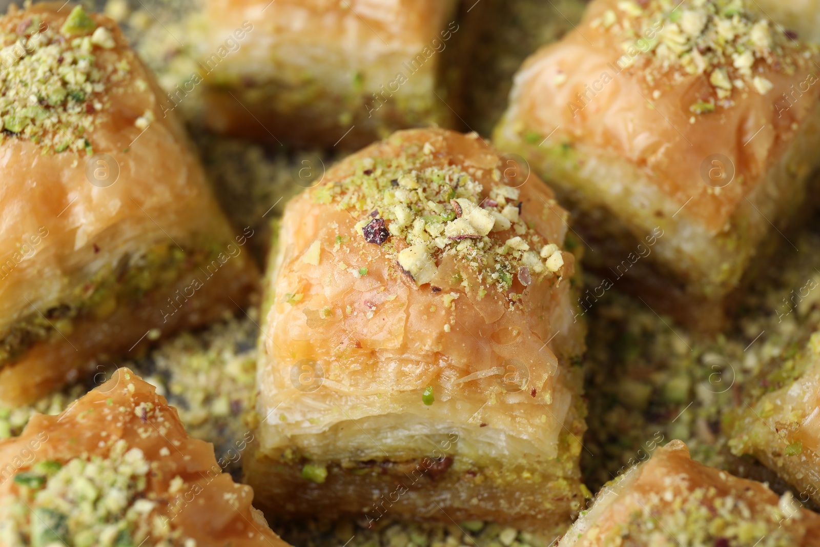 Photo of Delicious fresh baklava with chopped nuts on table, closeup. Eastern sweets