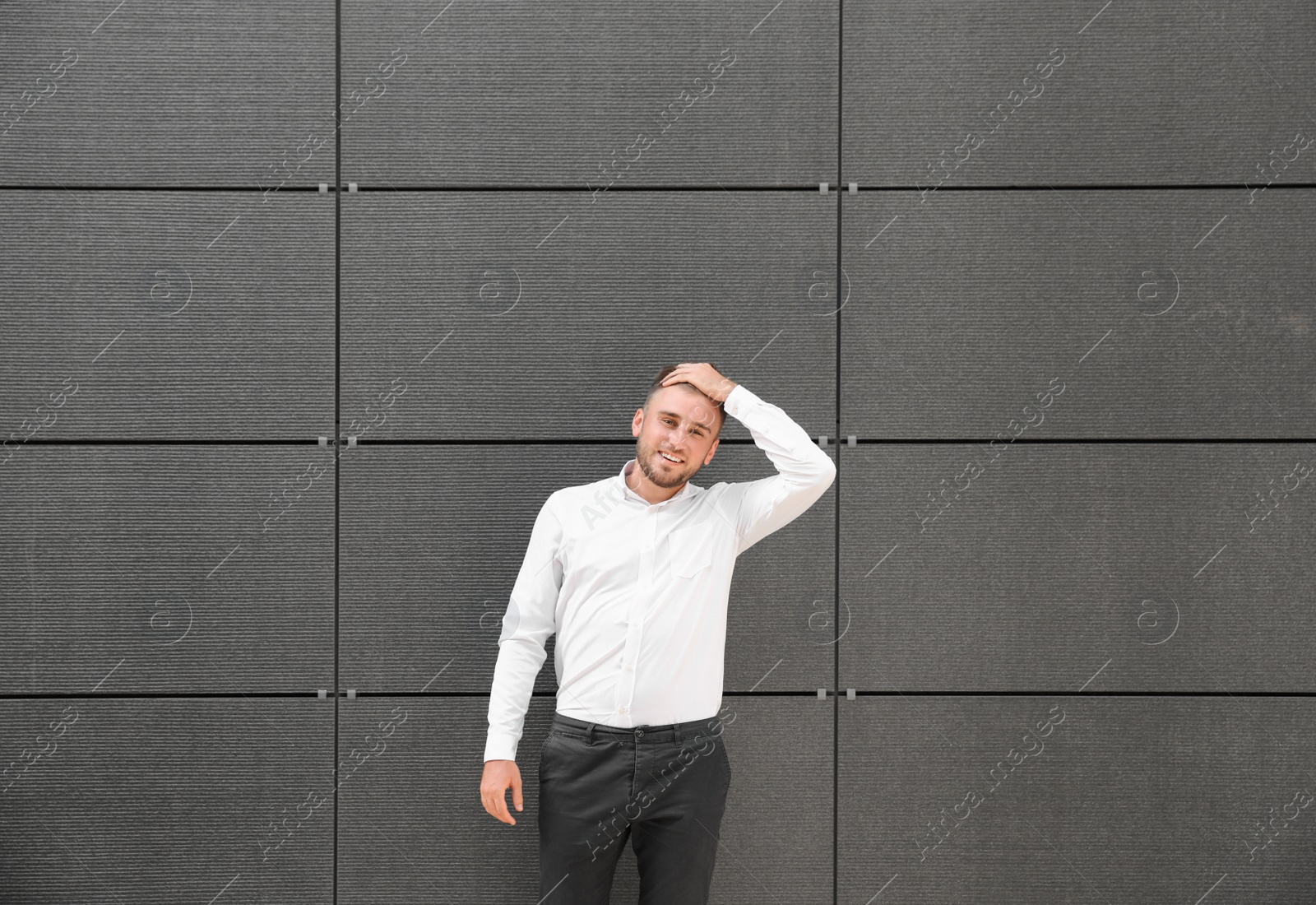 Photo of Portrait of handsome young man leaning to wall outdoors