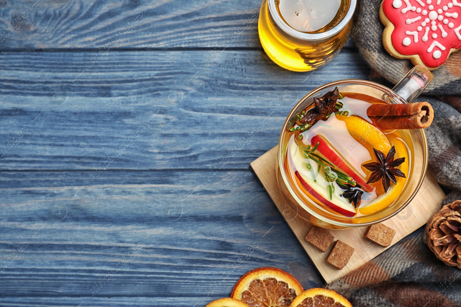 Photo of Aromatic mulled wine on blue wooden table, flat lay. Space for text