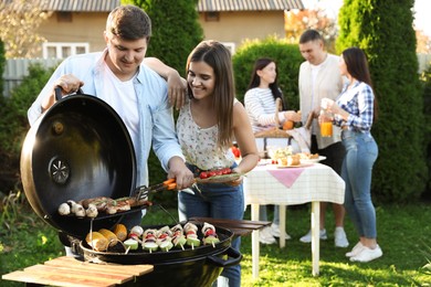 Photo of Group of friends having barbecue party outdoors