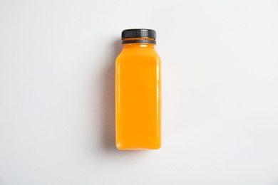 Photo of One bottle with tasty drink on color background, top view