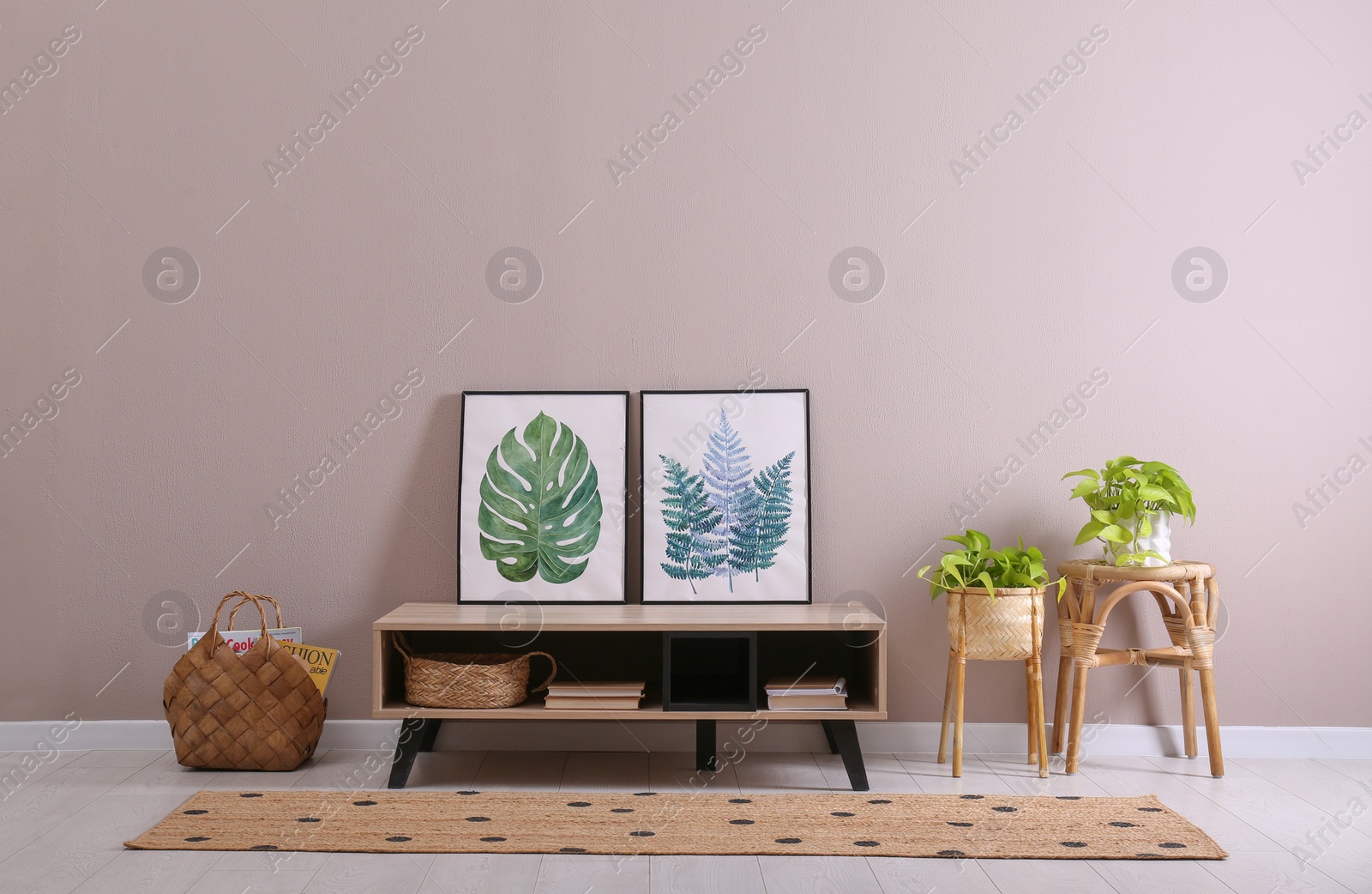 Photo of Elegant room interior with wooden cabinet and beautiful houseplants near beige wall