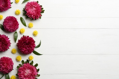 Photo of Beautiful asters and space for text on white wooden background, flat lay. Autumn flowers
