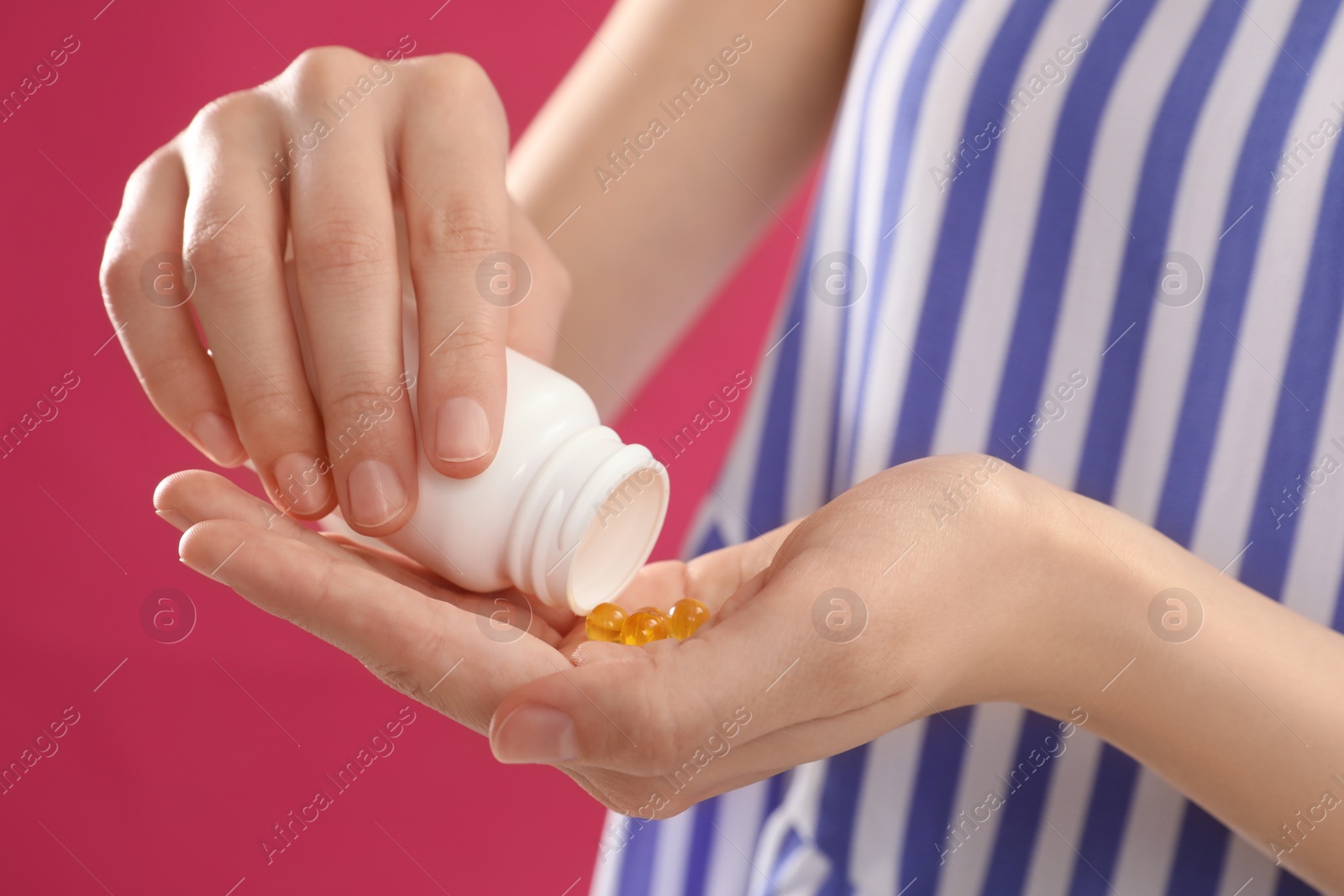 Photo of Young woman with bottle of vitamin pills on pink background, closeup