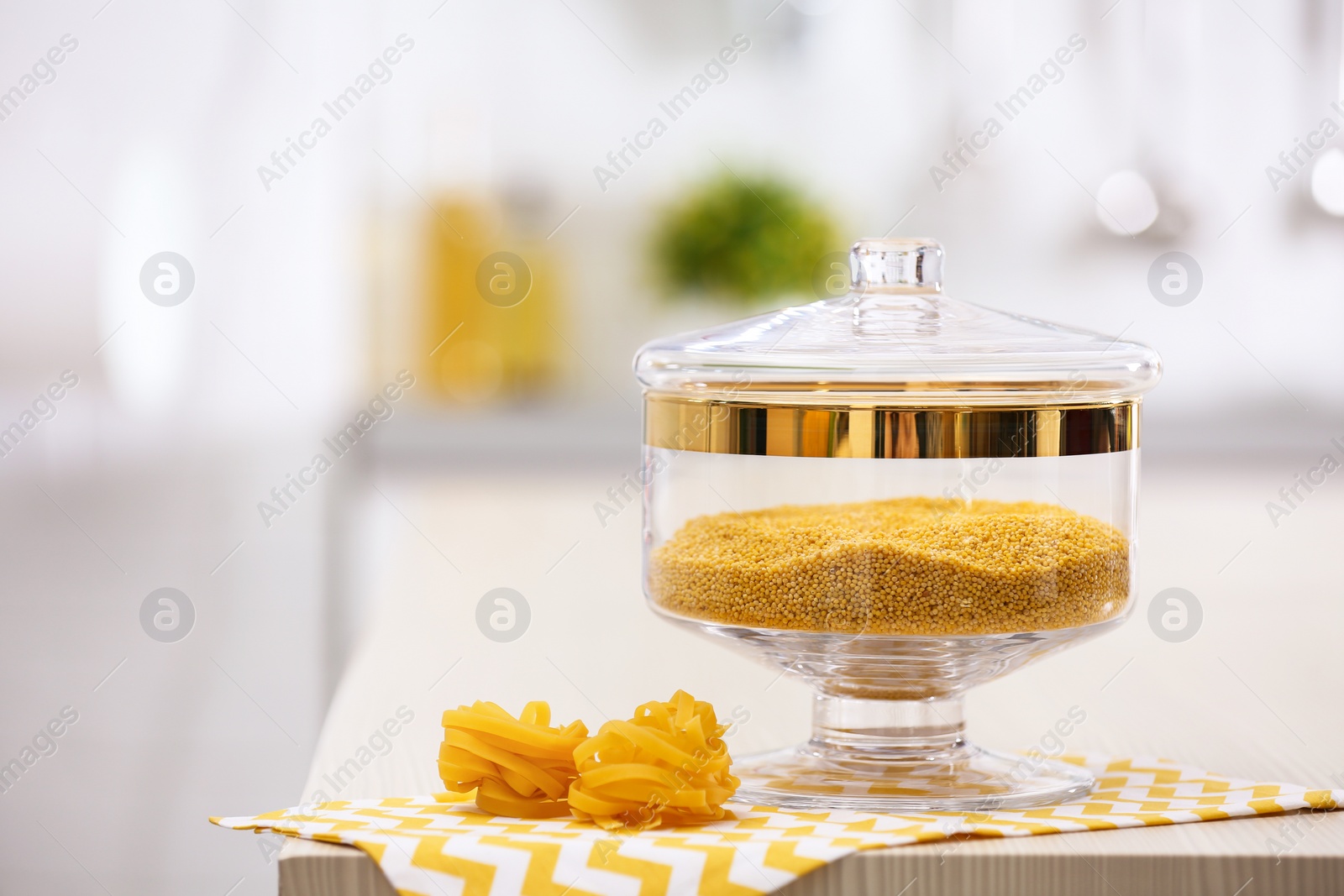 Photo of Raw pasta on wooden table in modern kitchen