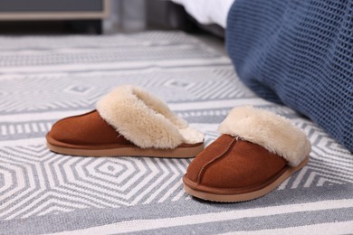 Photo of Brown soft slippers on carpet indoors, closeup